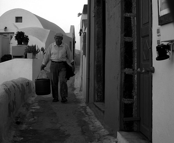 Genius Loci #68 by Jeremy Chin - Man Carrying Bucket, Santorini, Greece